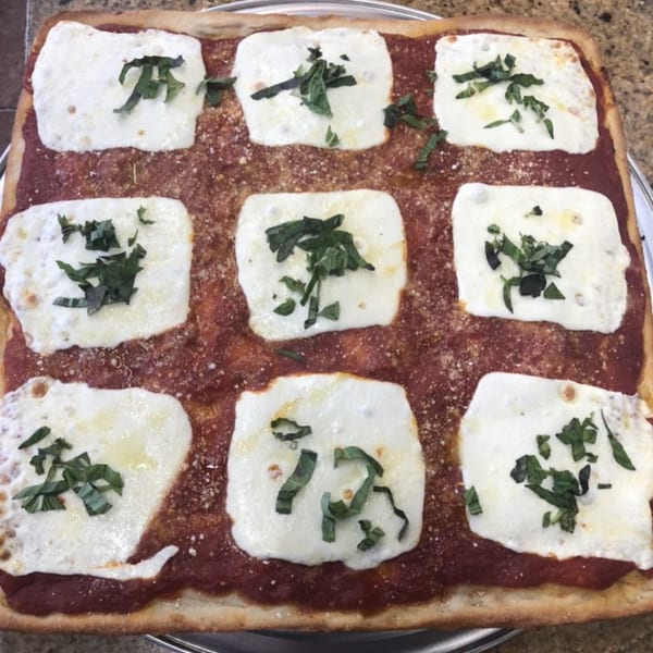 Fabio's Pizzeria's square pizza with nine dollops of fresh mozzarella and basil on red sauce.