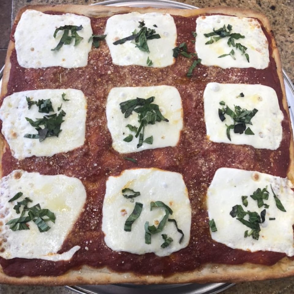 Fabio's Pizzeria's square pizza with nine dollops of fresh mozzarella and basil on red sauce.